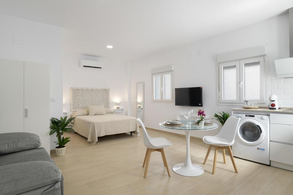 sala de estar blanca con mesa y cocina en Apartamento Maria A, en Vejer de la Frontera