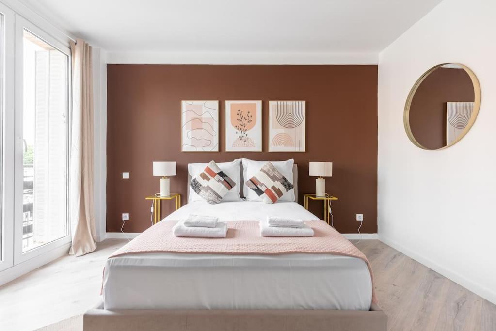 une chambre avec un grand lit et un miroir dans l'établissement Studio lumineux Paris Est -II, à Paris