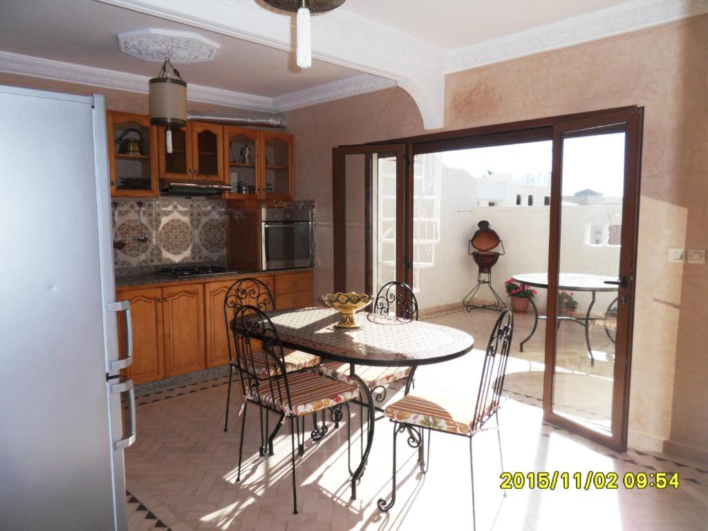 a kitchen with a table and chairs in a room at Appartement Terrasse Beau Soleil in Essaouira