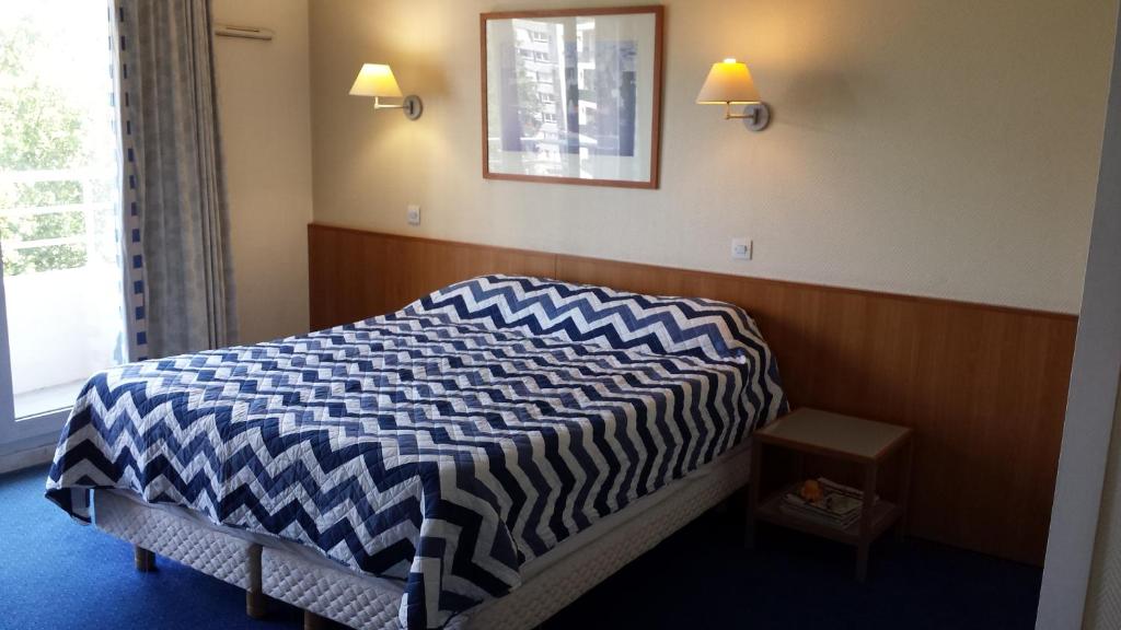 庫爾布瓦的住宿－巴黎拉德芳斯私人公寓，一间卧室配有一张带 ⁇ 子毯子的床