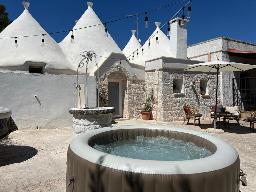 a hot tub in front of a white building at Trulli DOmimi'2024 in Martina Franca