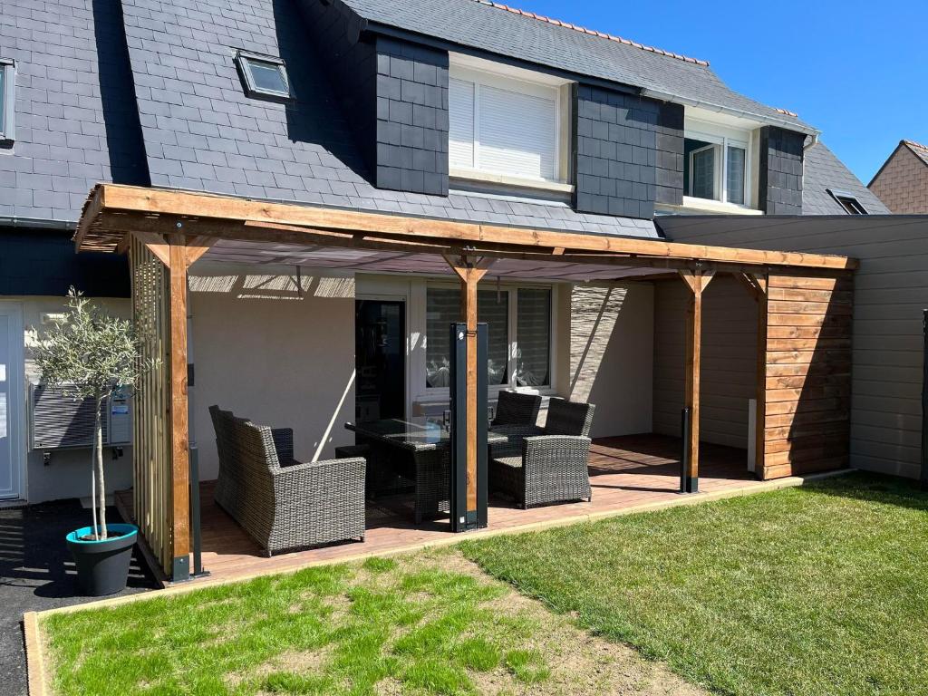 - un pavillon avec une table et des chaises sur la terrasse dans l'établissement Maison des Clos Biais, à Dinard