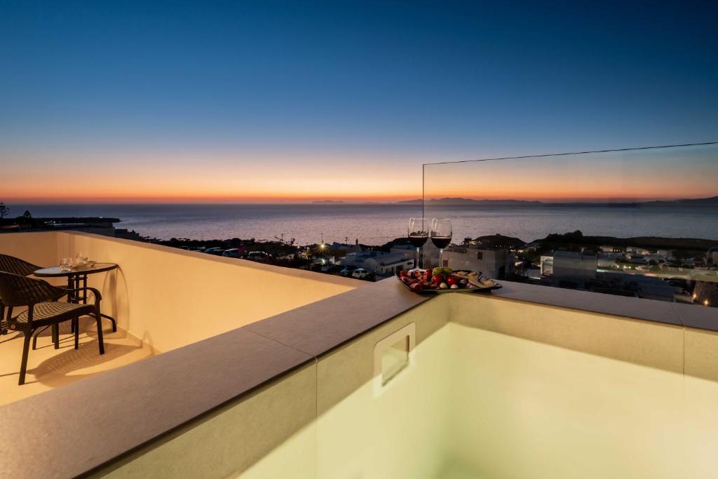 a balcony with a view of the ocean at dusk at Oia Lia in Oia