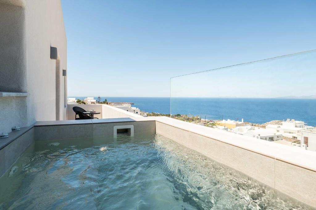 a hot tub on the balcony of a building at Oia Lia in Oia