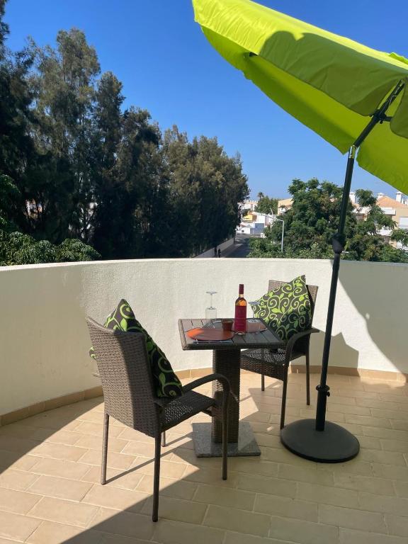 a table and chairs and an umbrella on a patio at Cabanas Beach Penthouse in Cabanas de Tavira