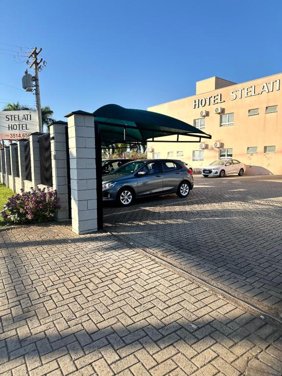 un coche aparcado en un aparcamiento frente a un hotel en Hotel Stelati, en Jaguariúna