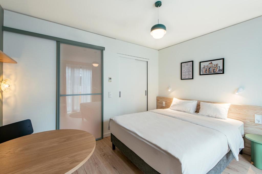 a bedroom with a large bed and a table at Aparthotel Adagio Muenchen City in Munich