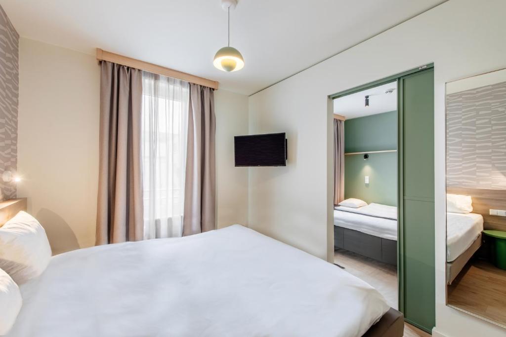a hotel room with a bed and a mirror at Aparthotel Adagio Muenchen City in Munich