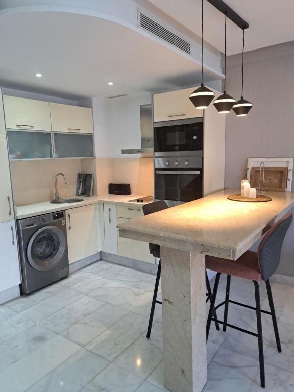 een keuken met een tafel, een wastafel en een vaatwasser bij Studio ALMASSIRA in Casablanca