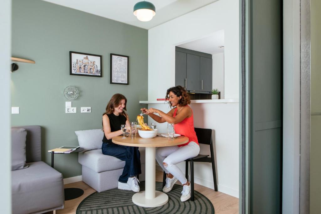 two women sitting at a table in a room at Aparthotel Adagio Muenchen City in Munich