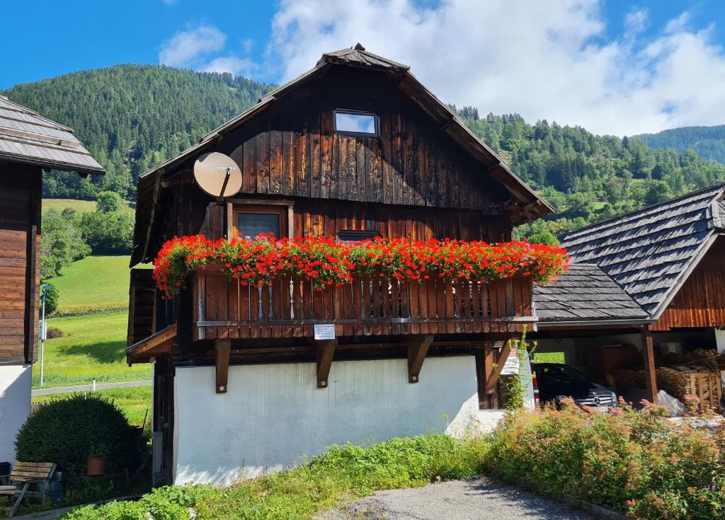 a house with flowers on the side of it at Die Alte Scheune by Globalimmoservice in Bad Kleinkirchheim