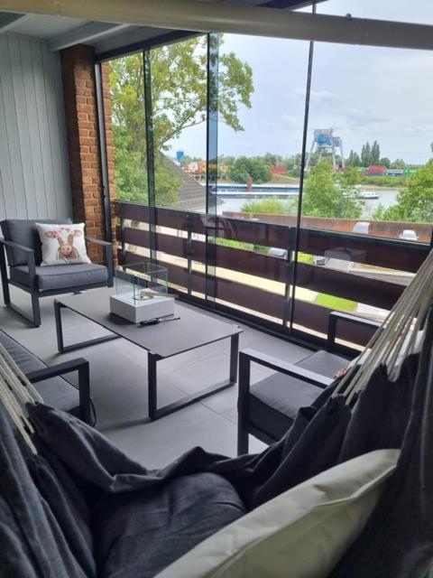 a living room with a hammock and a large window at Ferienwohnung Rheinpark Emmerich Rheinblick, Balkon & Parkplatz in Emmerich