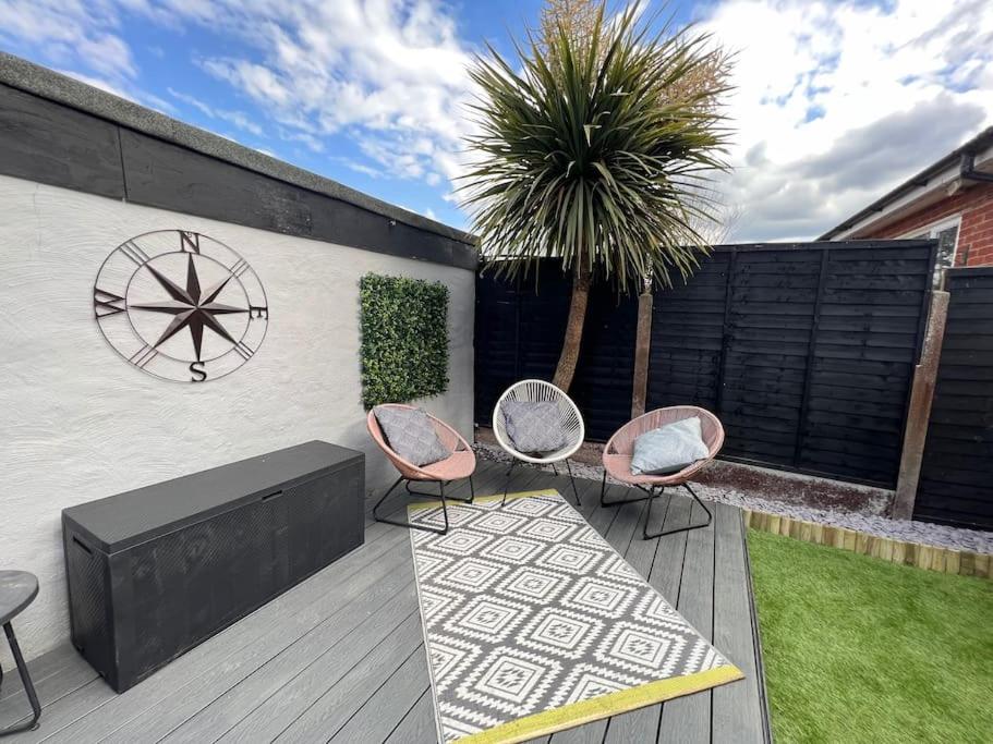 a patio with two chairs and a table on a deck at By Buildersbeds - Heaton House 2 Bedrooms in Havering atte Bower
