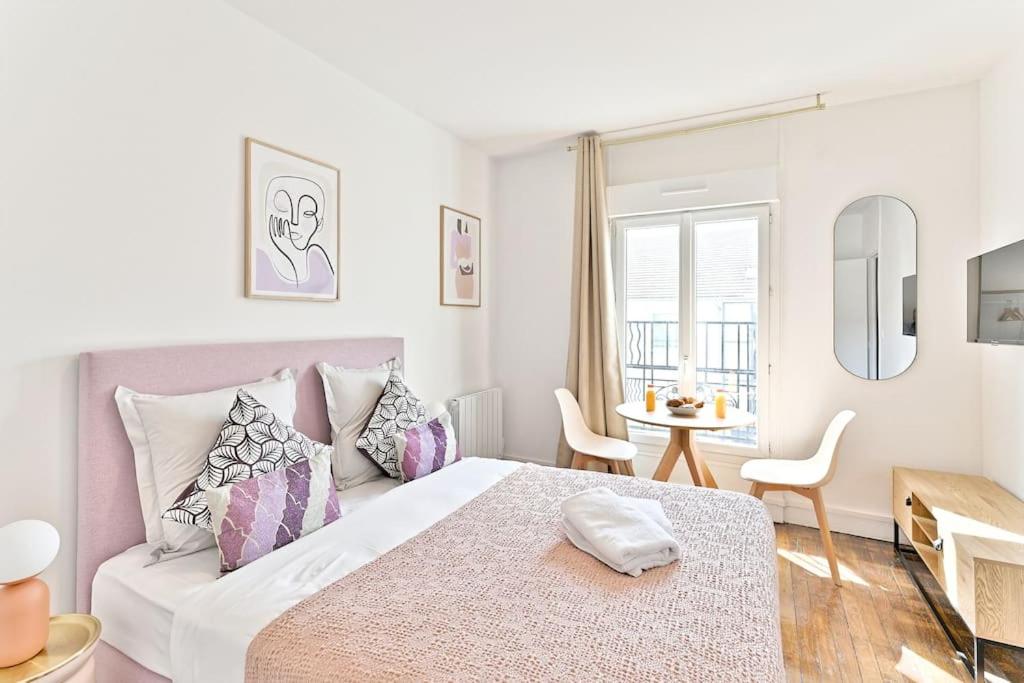 une chambre blanche avec un grand lit et une table dans l'établissement Magnifique studio neuf au centre de Montreuil, à Montreuil