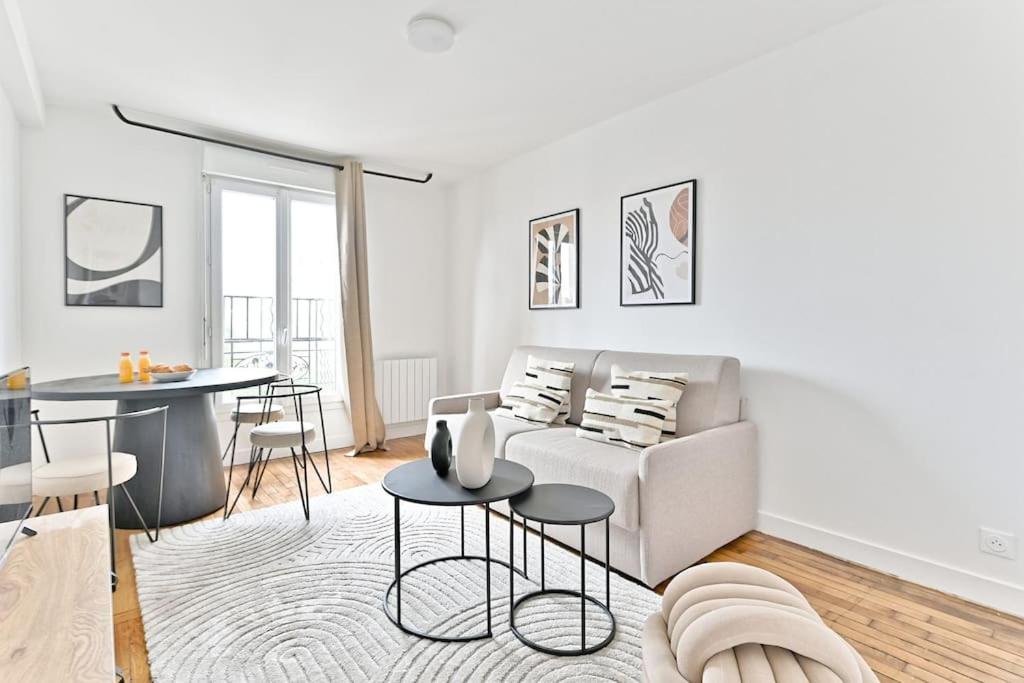 un salon blanc avec un canapé et une table dans l'établissement Appartement spacieux 50m2 Proche de la capitale, à Montreuil