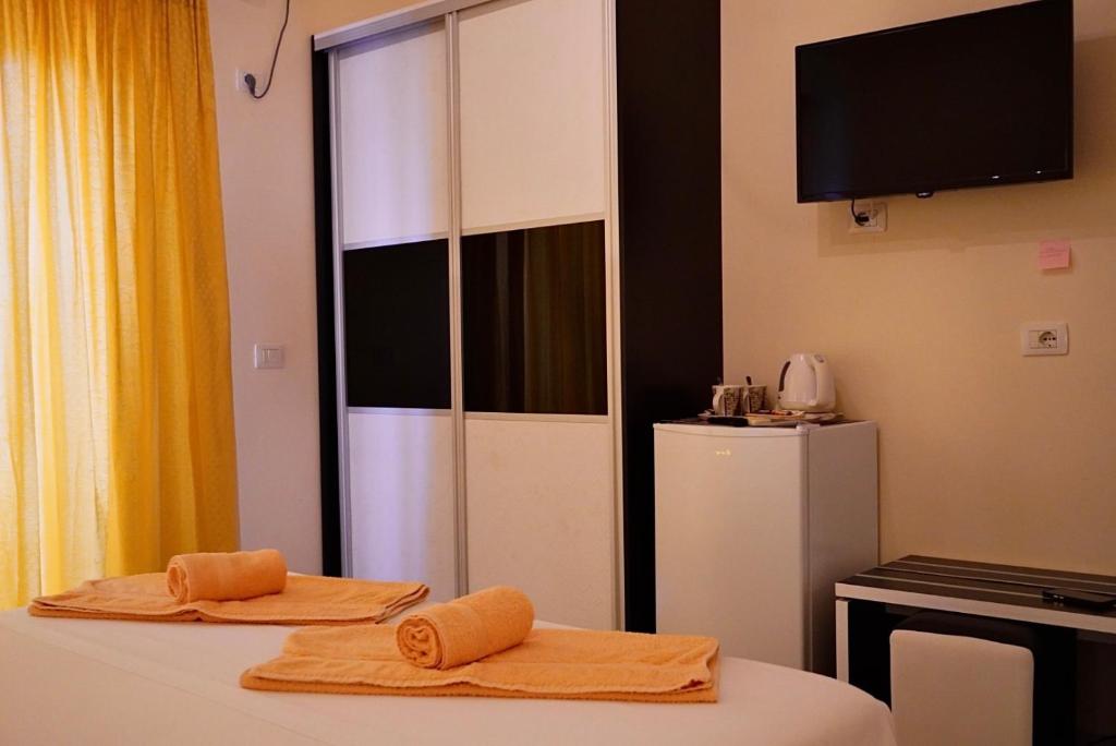 a room with a refrigerator and two towels on a table at Marku Palace in Ksamil
