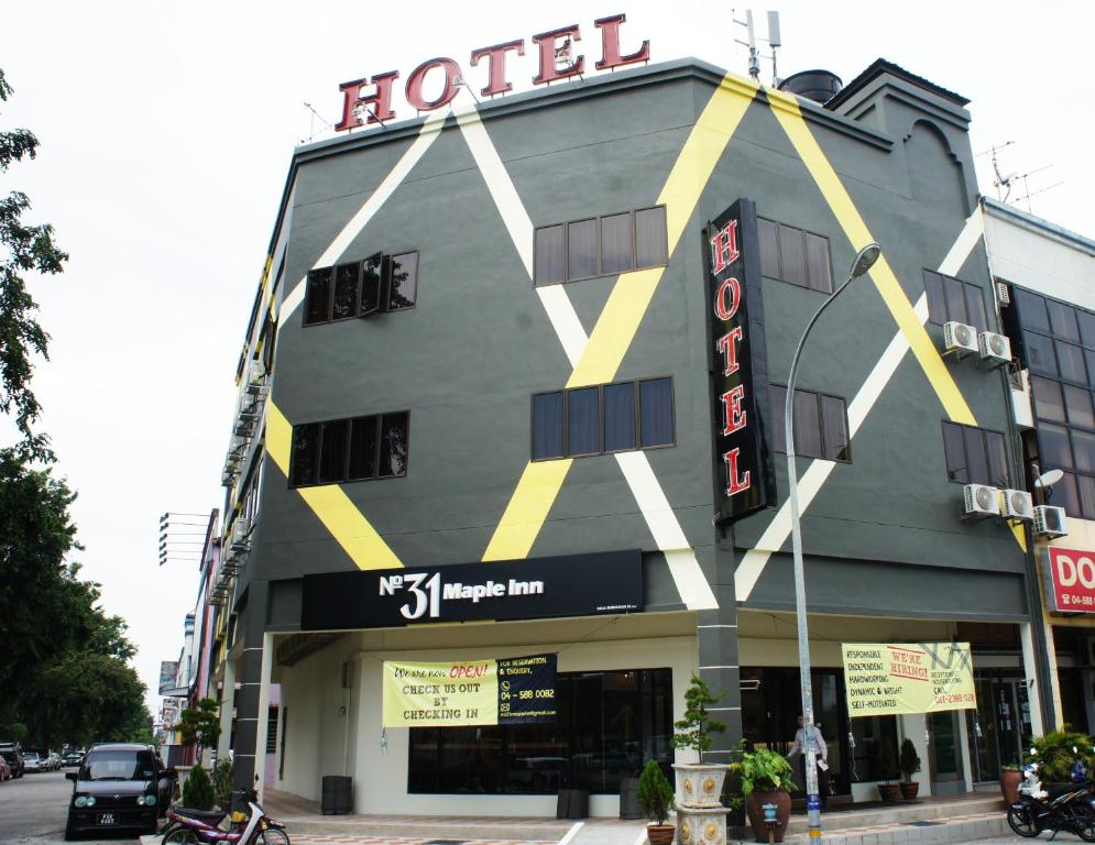 a hotel building with a sign on top of it at No.31 Maple Inn in Simpang Ampat