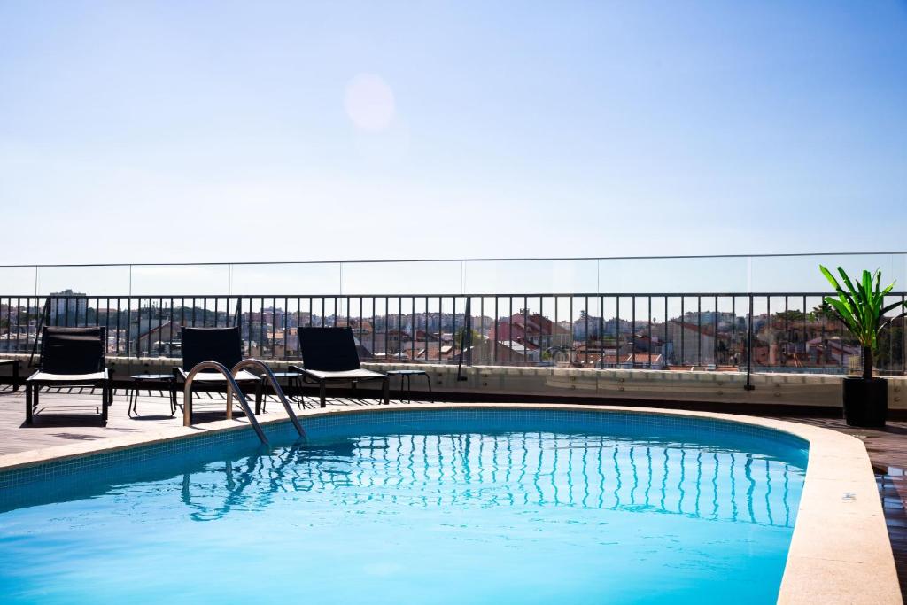 里斯本VIP Executive Suites do Marquês Hotel的建筑物屋顶上的游泳池