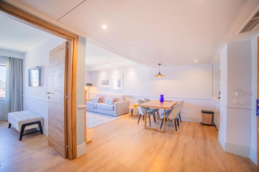 Un comedor y una sala de estar con mesa y sillas. en VIP Executive Suites do Marquês Hotel, en Lisboa