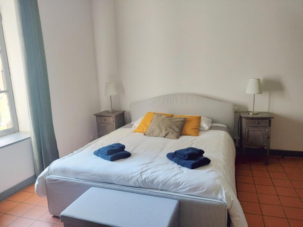 sypialnia z łóżkiem z dwoma niebieskimi ręcznikami w obiekcie Maison de Pierre 4 à 6 personnes w mieście Lempaut