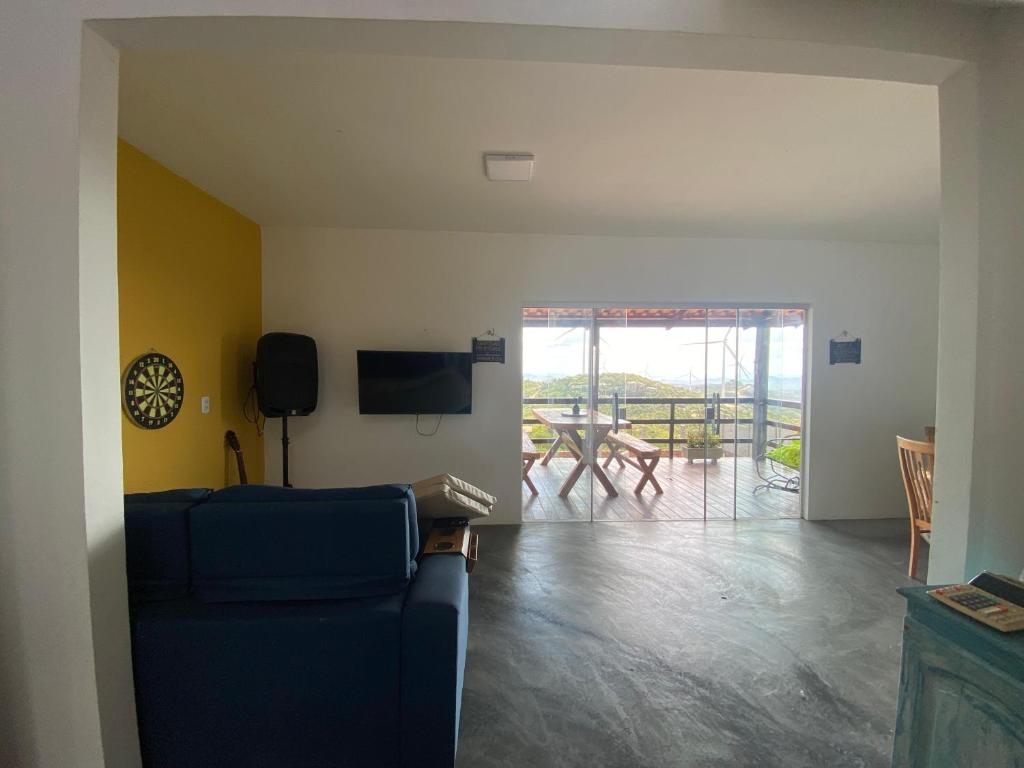 モンテ・ダス・ガメレイラスにあるChalé Vista Encanto dos Montesの青いソファとテーブルのあるリビングルーム