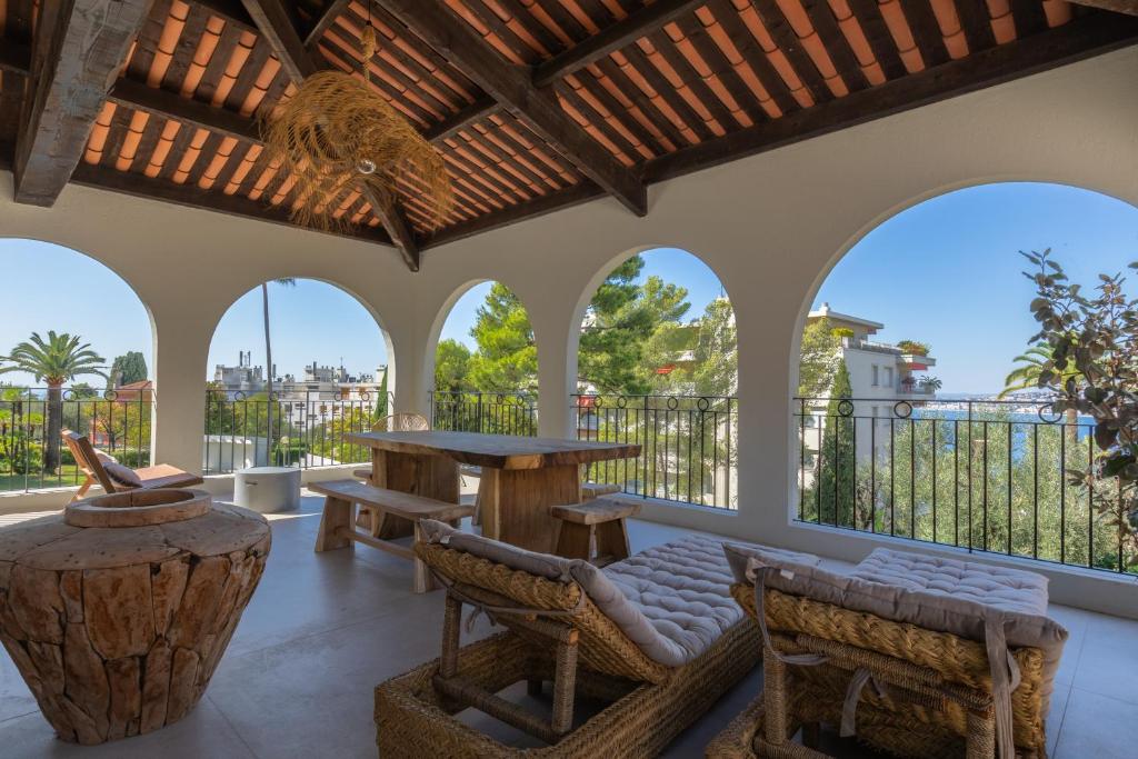 un patio avec une table, des chaises et des fenêtres dans l'établissement La belle Villa de J et J, à Nice