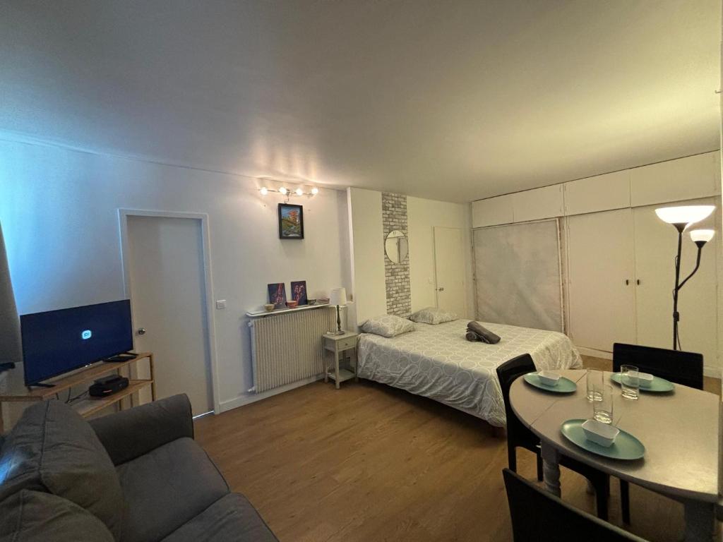 a small living room with a bed and a table at Appartement des Champs Elysées in Paris