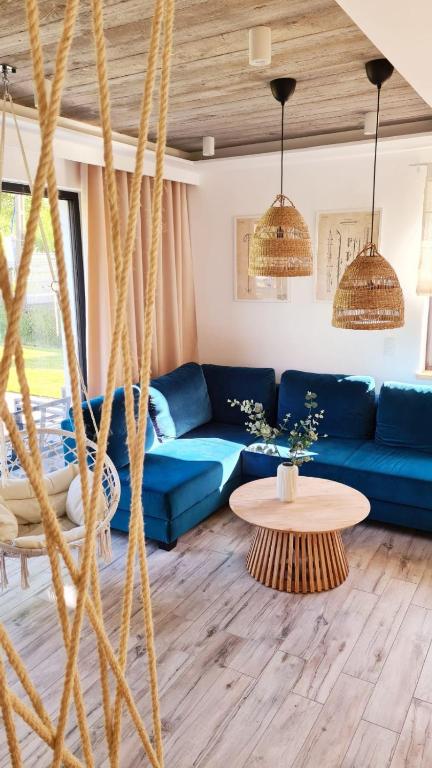 a living room with a blue couch and a table at Wyskocz w góry - domek z balią ogrodową in Szczyrk