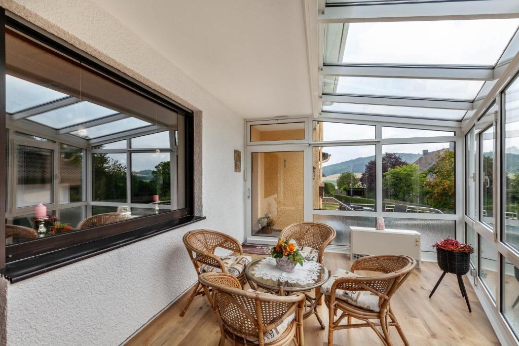 a room with a table and chairs and windows at Rosi's Ferienwohnung in Daun