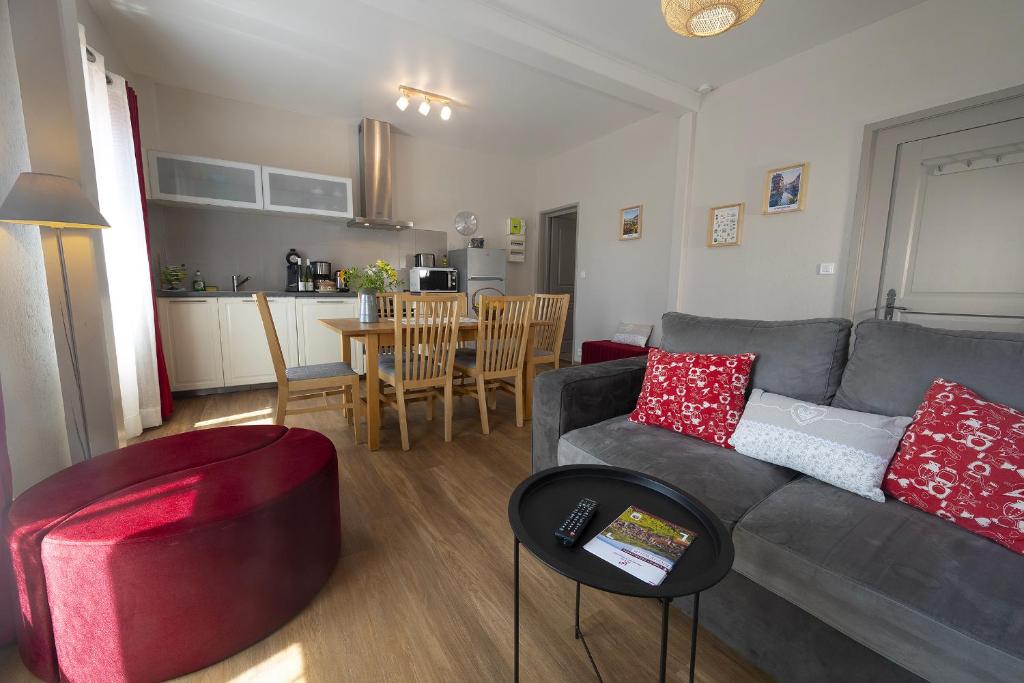 - un salon avec un canapé gris et des oreillers rouges dans l'établissement MUSCAT - Bel appartement rénové récemment - au pied du vignoble - parking gratuit, à Riquewihr