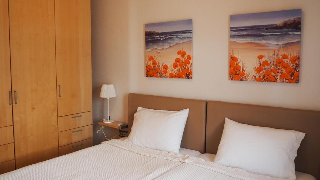 ein Schlafzimmer mit einem Bett mit zwei Gemälden an der Wand in der Unterkunft Summer house in Halkidiki in Paralia Dionisiou
