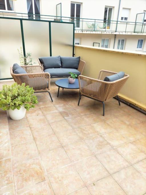 d'une terrasse avec des chaises et un canapé sur un balcon. dans l'établissement Cosy flat in Beauvais city center, à Beauvais