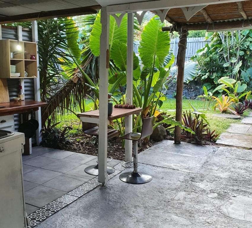 un patio con tavolo, panca e piante di Hidden Garden a Cannonvale