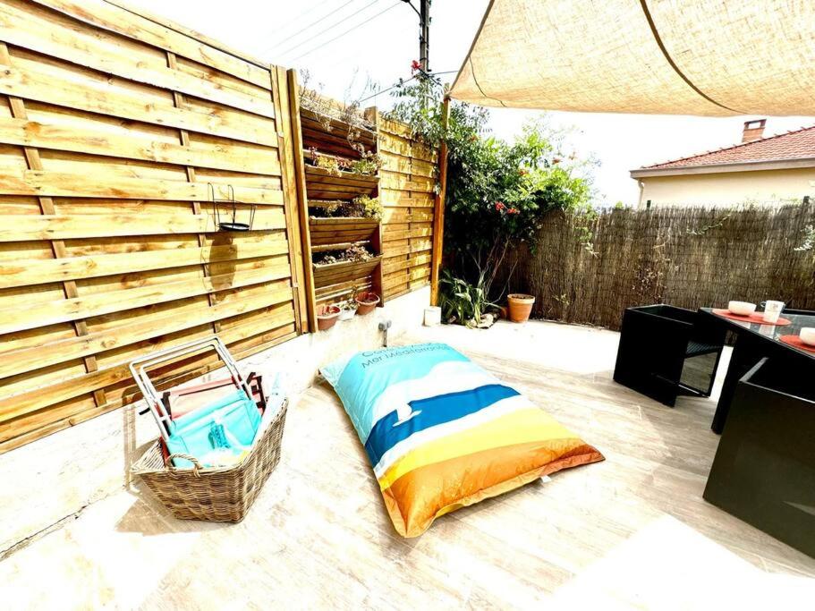 - une terrasse avec un oreiller à côté d'une clôture dans l'établissement Casa Di Loubet- Aperçu Mer-Parking- Plage à 10 min à pied - CapitalChic Services à Villeneuve Loubet Plage, à Villeneuve-Loubet