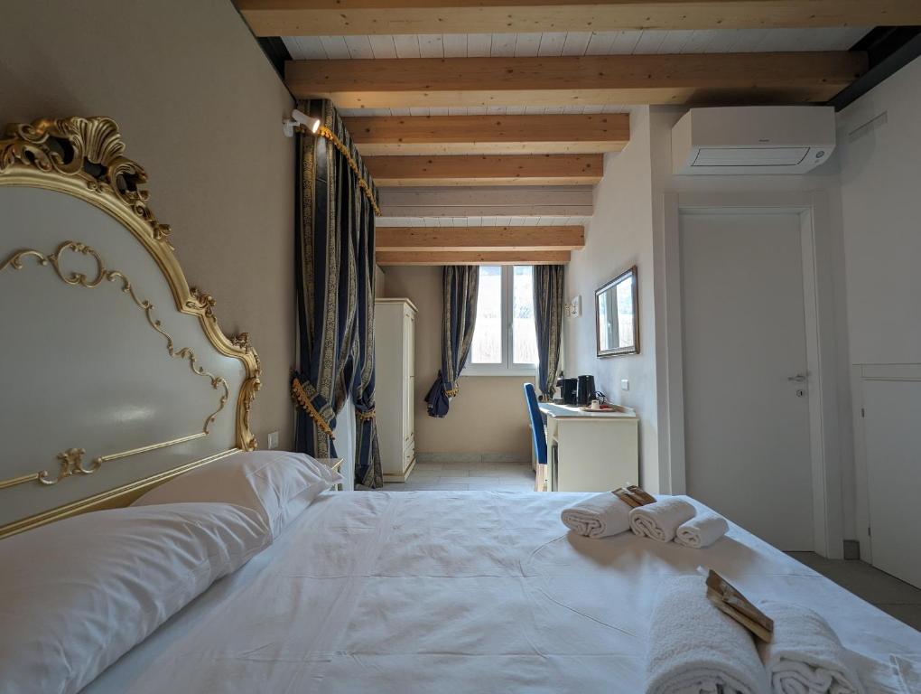 a bedroom with a large white bed with towels on it at FloVe' Rooms Venice in Venice