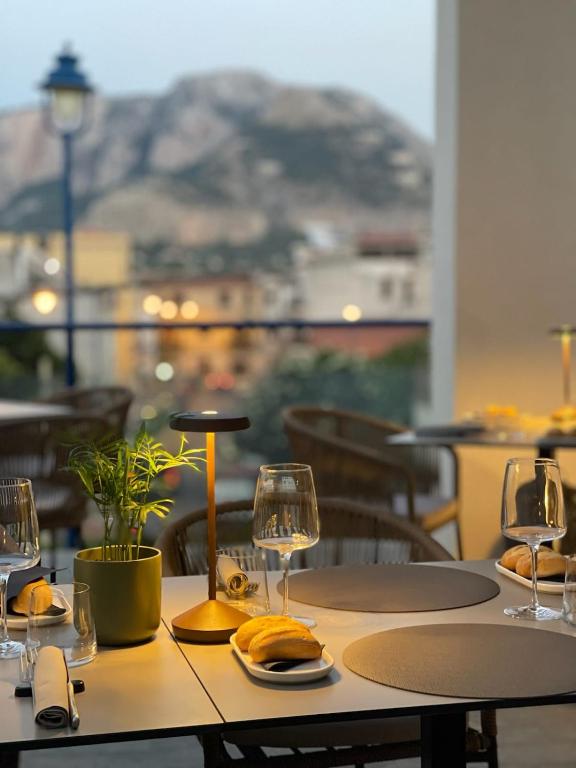 a table with glasses and plates of food on it at Mondello Glam Hotel & Terrace in Mondello