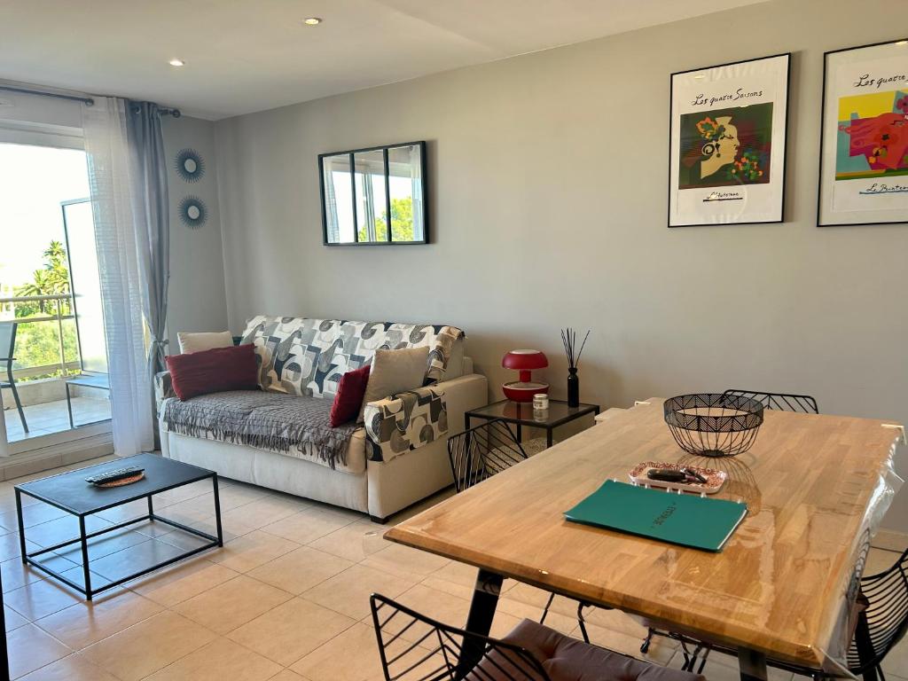 un salon avec une table et un canapé dans l'établissement Joli 2p climatisé dans résidence calme et securisée avec piscine, à Antibes