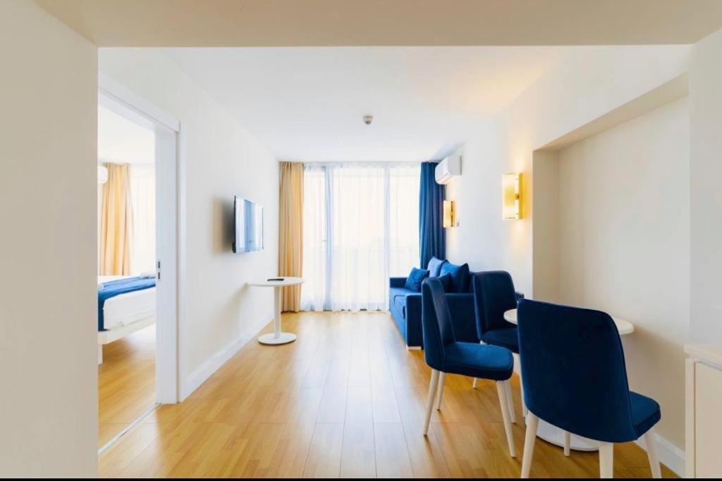 ein Wohnzimmer mit blauen Stühlen und einem Tisch in der Unterkunft Семейный люкс на первой линии in Batumi