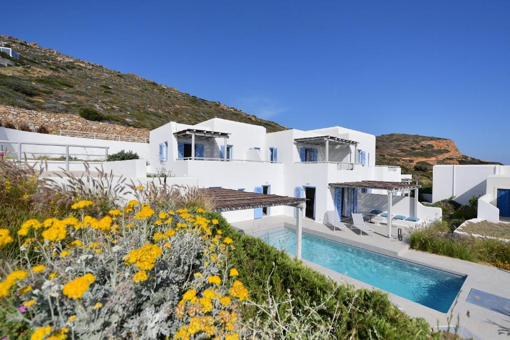 a white villa with a swimming pool and flowers at Ariti's Villas 1 - Naxos in Naxos Chora