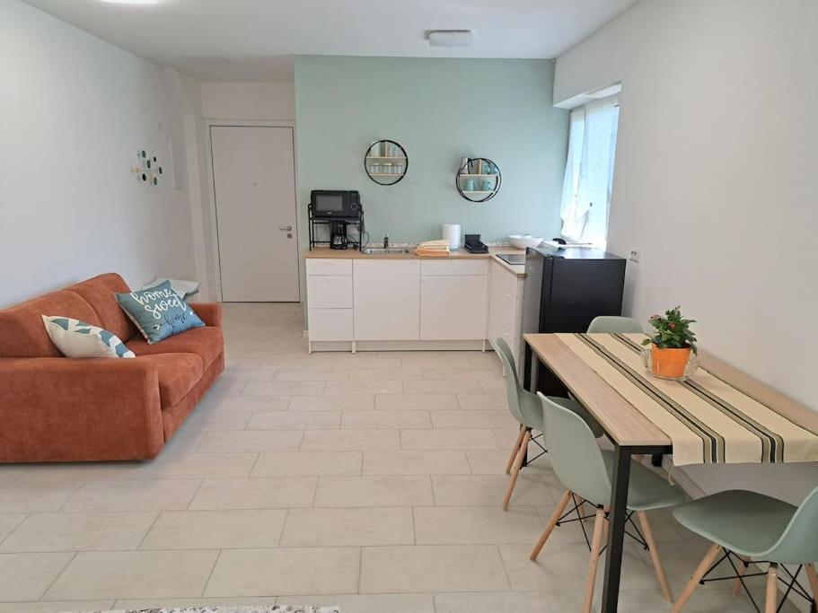 a living room with a couch and a table with chairs at Esther house monolocale in Terlano
