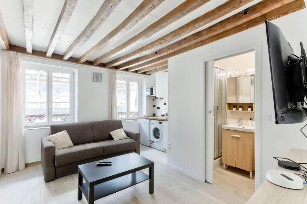 un salon avec un canapé et une table dans l'établissement Studio 5mn walk from Oberkampf metro station, à Paris