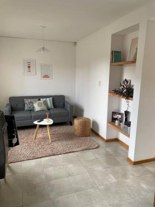 una sala de estar con un sofá y una mesa en Duplex con Excelente ubicación, en Esquel