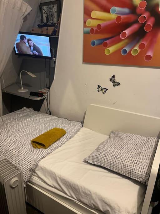 - une chambre avec un lit et une télévision murale dans l'établissement Chambre Arc Triomphe Champs Elysees, à Paris