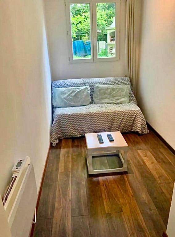une petite pièce avec un lit et une table dans l'établissement Petit appartement idéal pour deux personnes, offrant une belle vue sur jardin, proche des commodités et à moins de 30 minutes de Paris en transport, à Chennevières-sur-Marne