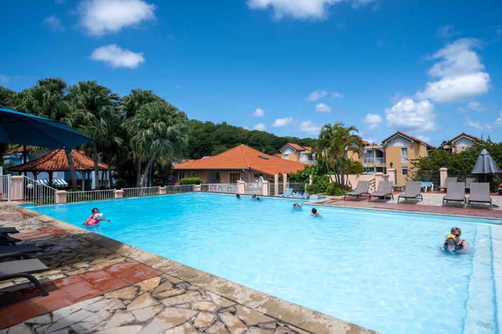un gruppo di persone in una piscina in un resort di Kay lanmou location de vacances Sainte Anne a Sainte-Anne