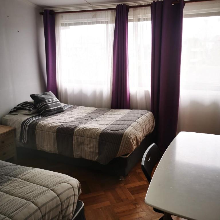 Una cama o camas en una habitación de Hostal Vivo Concepción