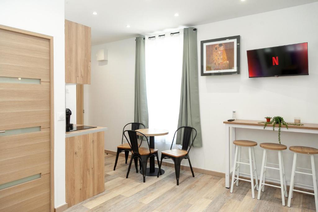 a room with a table and chairs and a bar at Villa Des Bégonias - PSG in Le Pré-Saint-Gervais