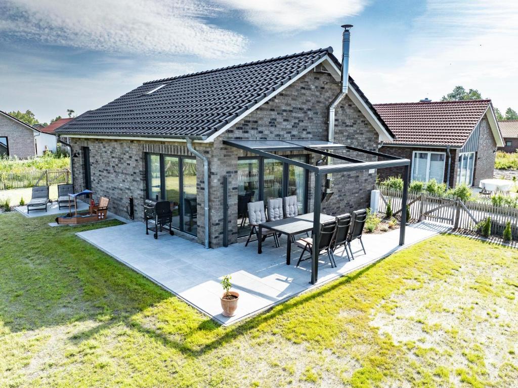 una casa con un patio con mesa y sillas en Haus Wieken-Huus, en Sehestedt