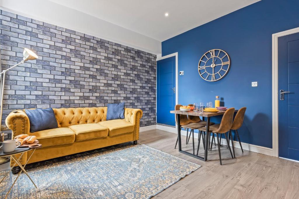 a living room with a yellow couch and a table at 4 Beds 3 Bath (2-ensuites) Free Parking 75Mbps in Stoke on Trent