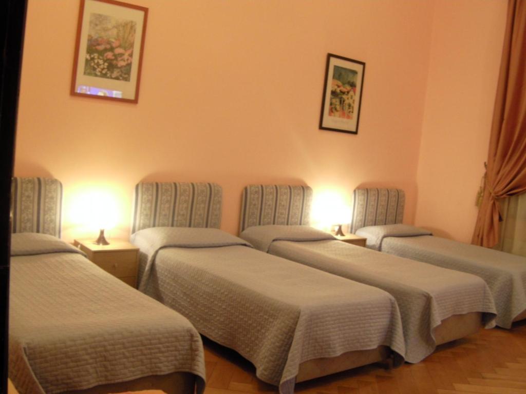 a room with three beds in a room at Affittacamere Alla Stazione in Trieste